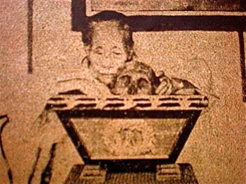 Teodora Alonso shows visitors Rizal's skull from the urn.  Photo courtesy of Dr. Ambeth R. Ocampo